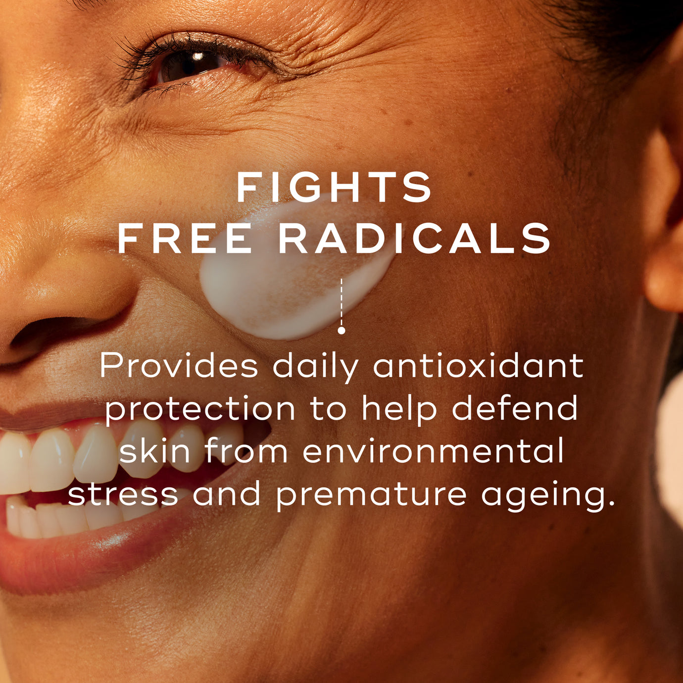 Close-up of a smiling person’s face on a warm orange background. Text reads: ‘Fights Free Radicals.’ Supporting text reads: ‘Provides daily antioxidant protection to help defend skin from environmental stress and premature ageing.